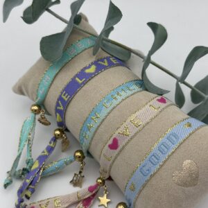 Bunte Festival-Armbänder von CADI mit goldenen Charms und funkelnden Botschaften – handgemachter Statement-Schmuck